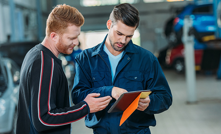 Técnico y cliente en la revisión tecnomecánica de los carros eléctricos