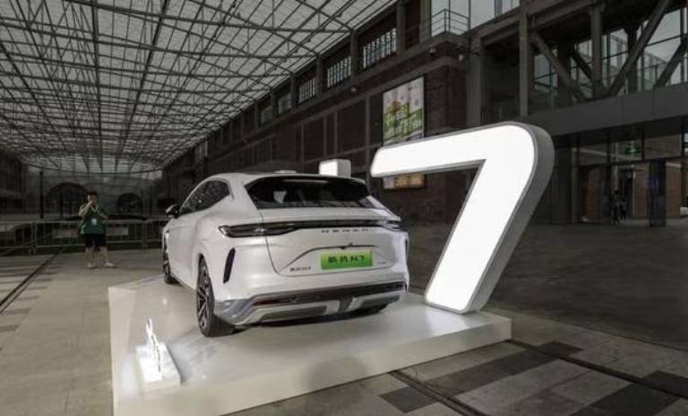 Presentación del BYD Denza N7, el vehículo está sobre una plataforma blanca.