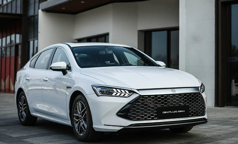 Carro Qin Plus de color blanco estacionado en una calle
